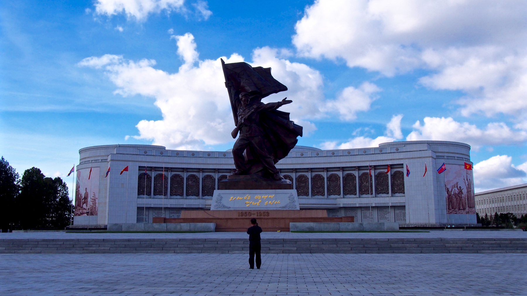 The war museum in Pyongyang, depicting a revolutionary soldier raising the flag of the DPRK. Our cameraman captures the moment we arrive, just as he captures all moments.